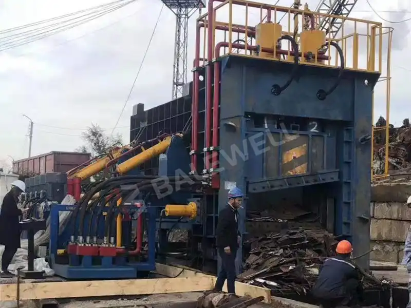 Engineers installing the HBS-630 Metal Shear Baler in Kazakhstan, showcasing the machine’s robust design and hydraulic components.