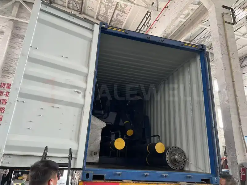 Balewell loading metal baler into container